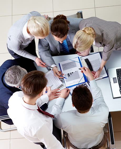Office workers holding a meeting while looking at documents together